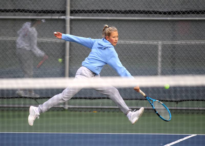Nazareth’s Layden Almer reaches for the ball during the first day of the IHSA state tennis tournament at Rolling Meadows High School on Thursday, Oct. 20, 2022.
