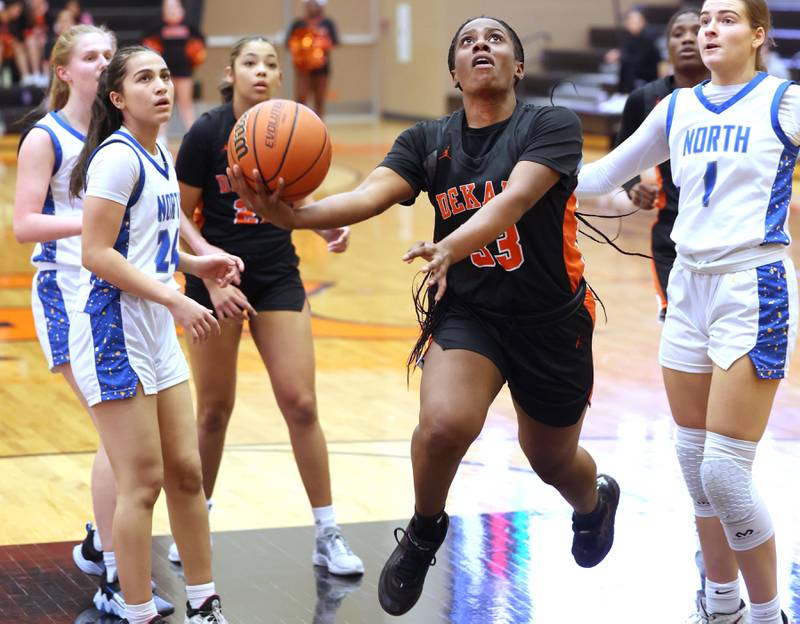 DeKalb’s Cayla Evans gets between two Wheaton North defenders for a shot during their Class 4A regional game Monday, Feb 12, 2024, at DeKalb High School.