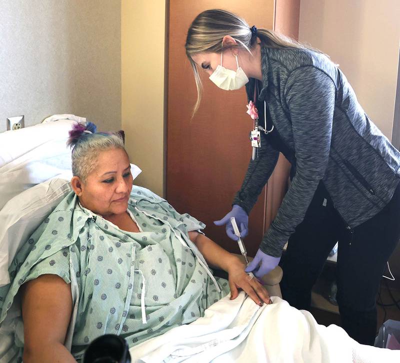 Travel nurse Alexandra Pop treats patient Maria Gallardo, of DeKalb, Wednesday, March 23, 2022, at Northwestern Medicine Kishwaukee Hospital in DeKalb.