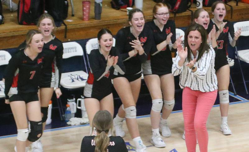 Members of the Woodland volleyball team react after scoring a point against Marquette on Thursday, Oct. 19, 2023 at Bader Gym.