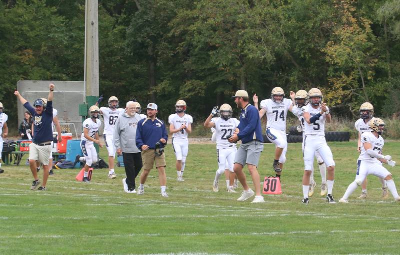The Marquette sideline celebrates after a Crusaders touchdown against St. Bede during the homecoming game Saturday, Sept. 28, 2024, at St. Bede Academy.