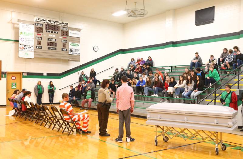 Felecia Rasmussen, La Salle County Deputy Sheriff speaks to Leland High School students with student Alex Todd during a Mock Prom drill at Leland High School on Friday, May 6, 2022 in Leland. A casket was placed into the gymnasium after Todd died in a fake accident.