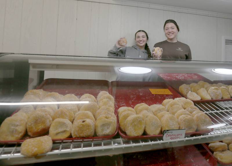 Emily Rodriguez and Jordyn McCoy hold Paczki's while fulfilling orders on Tuesday, March 4, 2025 at the Spring Valley Bakery. Paczki day is a Polish tradition of a jelly-filled doughnut consumed on Fat Tuesday the day before the Lenten season.