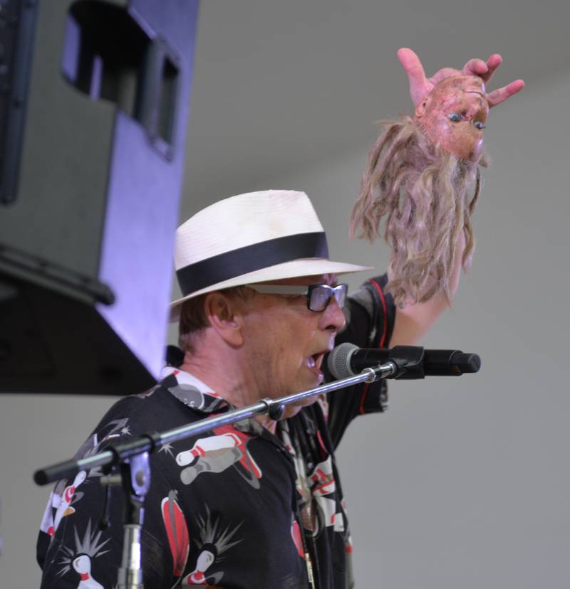 One of the band members of  Captain Rat and the Blind Rivets holds a doll's head as he sings a song from the 1960s during the Mt. Morris Jamboree on Friday, Aug. 15, 2025.