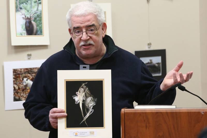 Jim Rendant holds his best of show photo of milkweed that he brought home and photographed using a scanner during the Starved Rock Photography Show awards on Saturday, Jan. 4, 2024 at the Starved Rock Visitors Center.