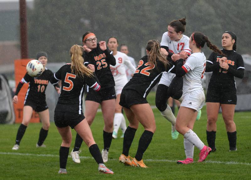 Oregon's Teagan Champley (17) heads the ball on a corner kick as Byron's Claire Henkel (5),  Arianna Irvin (25), and Delaney Henert (22) defend  on Thursday, April 18, 2024 at Byron High School. The Tigers won the game 2-1.