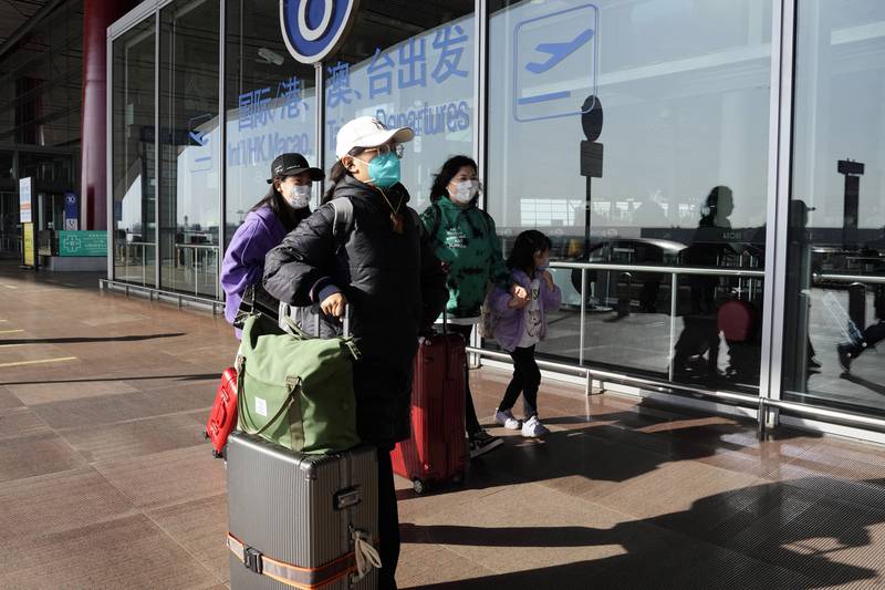 FILE - Passengers wearing masks walk through the Capital airport terminal in Beijing on Dec. 13, 2022. On Wednesday, Dec. 28, 2022, the U.S. announced new COVID-19 testing requirements for all travelers from China, joining other nations imposing restrictions because of a surge of infections. (AP Photo/Ng Han Guan, File)