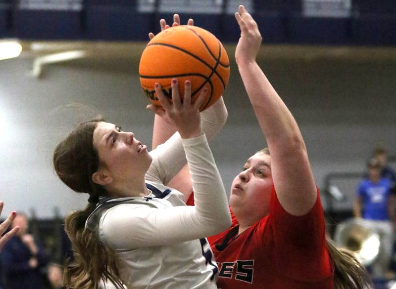 Oswego East's Lillie VanDyke tries to score over Yorkville's Madison Spychalski during their game Tuesday, Feb. 11, 2025, at Oswego East High School.