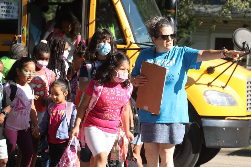 Teacher Kathy Ramsay directs students off the bus as they arrive on the first day of school at Woodland Elementary School in Joliet. Wednesday, Aug. 17, 2022, in Joliet.