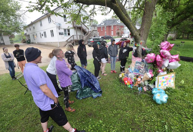 Visitors and friends gather to pay their respects during a memorial for slain teen Gracie Sasso-Cleveland Friday, May 12, 2023, behind a building in the 500 block of College Avenue in DeKalb.