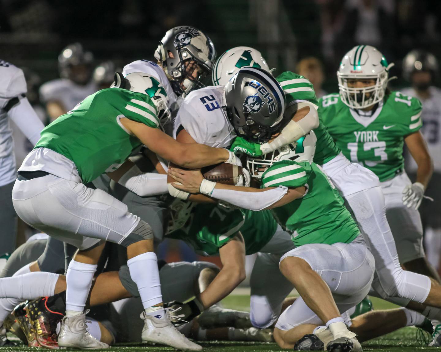 Oswego East's Oshobi Odior (23) is swarmed by the York defense during Class 8A Playoff football game between Oswego East at York.  Oct 28, 2022.
