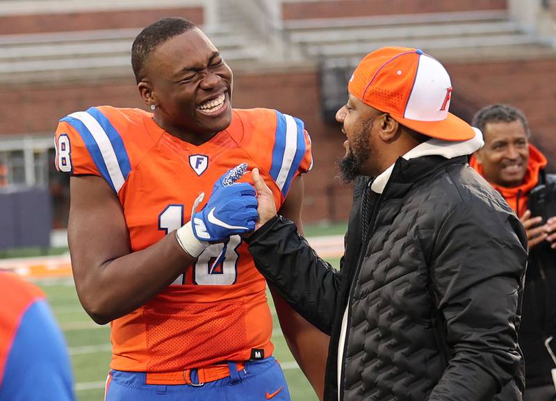 East St. Louis' Austin Franklin celebrates with a coach after their IHSA Class 6A state championship win over Prairie Ridge Saturday, Nov. 26, 2022, in Memorial Stadium at the University of Illinois in Champaign.