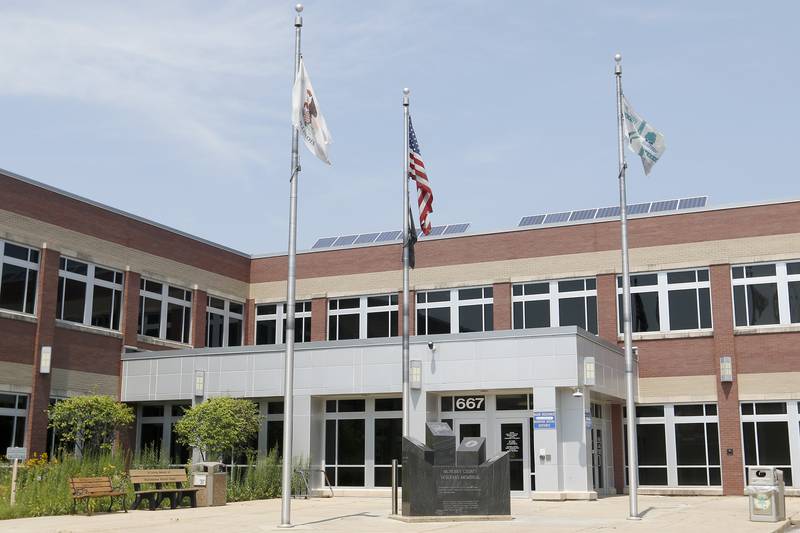 Flags attempt to fly on a relatively still day at the McHenry County Administrative Building on Monday, July 26, 2021 in Woodstock.