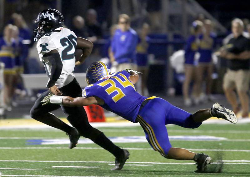 Woodstock North's David Randecker runs out of the tackle attempt by Johnsburg's Duke Mays during a Kishwaukee River Conference football game on Friday, Sept. 26, 2025, at Johnsburg High School.
