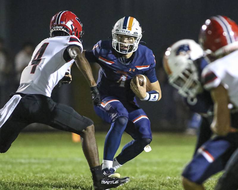 Oswego's Drew Kleinhans (4) comes face to face with Yorkville's Jayden Ruth (4) on a scramble during football game between Yorkville at Oswego Friday, Sept 26, 2025 in Oswego.