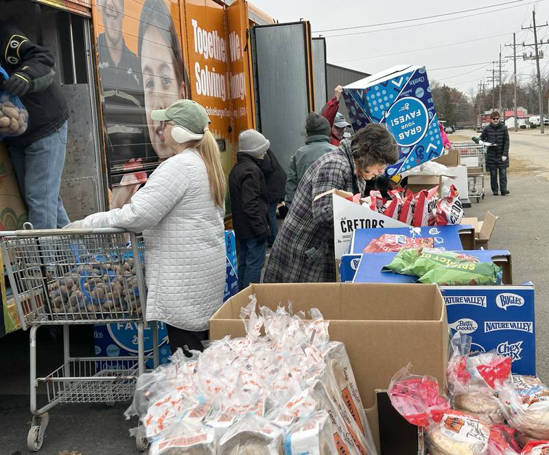 Polo Lifeline Food Pantry director Kathy Wragg (center) helps other pantry volunteers distribute food items from the Northern Illinois Food Bank's mobile market truck on Wednesday, Nov. 19, 2025 in Polo. People waited in their vehicles and took turns to receive the food during the morning event.
