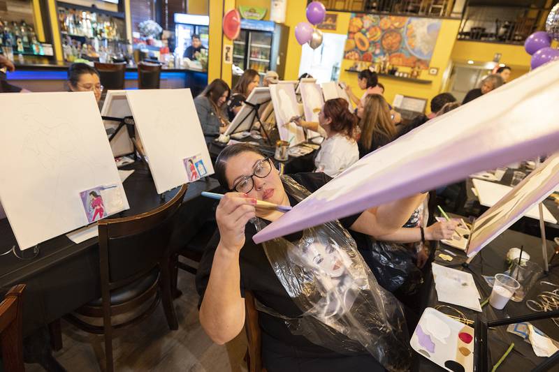 Miriam Ferrel of Rock Falls paints the edge of her canvas Monday, April 15, 2024 during the Selena paint party.