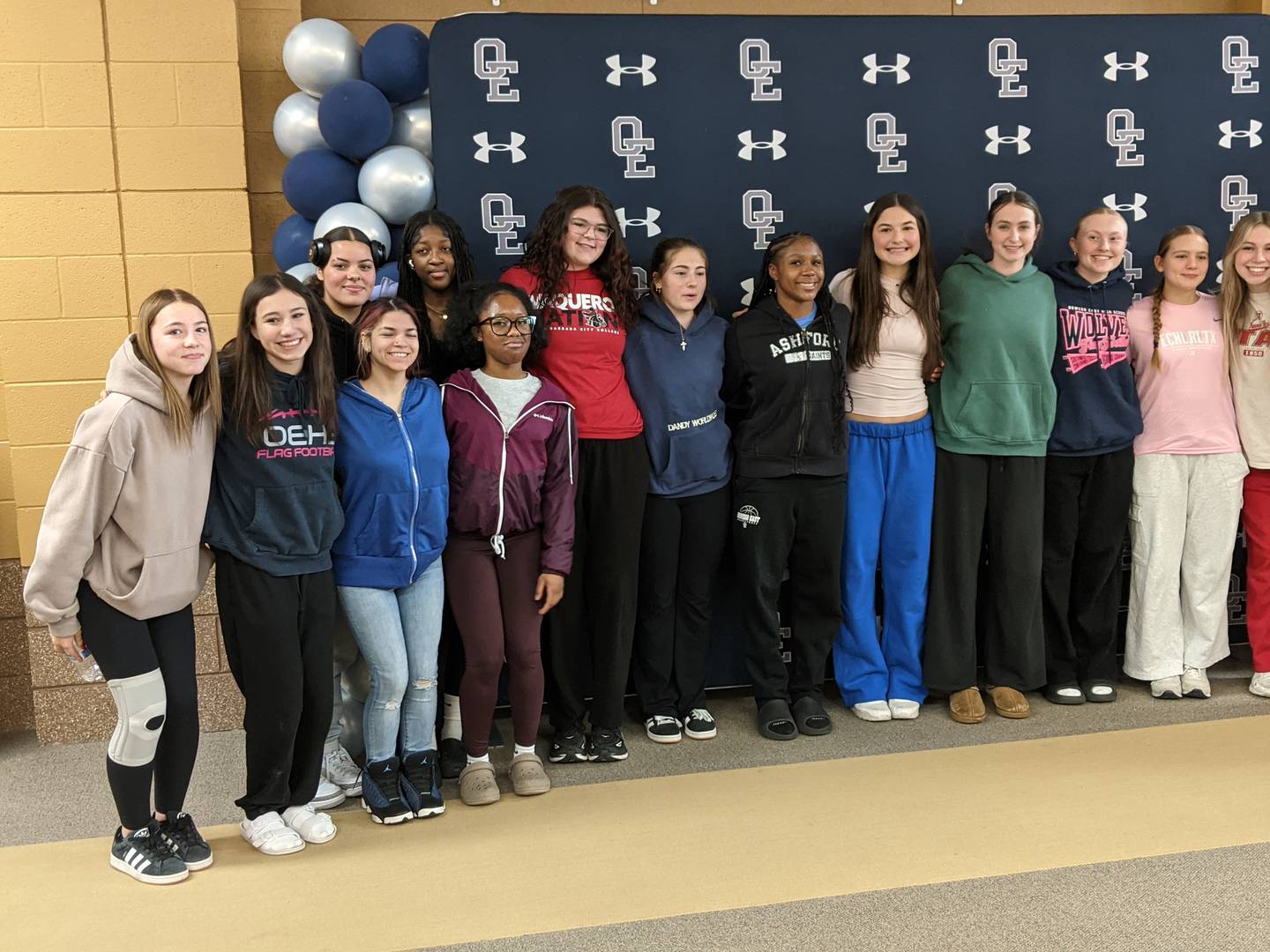 Oswego East High School Junior Danielle Stone, center, stands with her fellow girls flag football players after being presented with the Chicago Bears Community High School All-Star Award at the school on Wednesday, March 4, 2026.