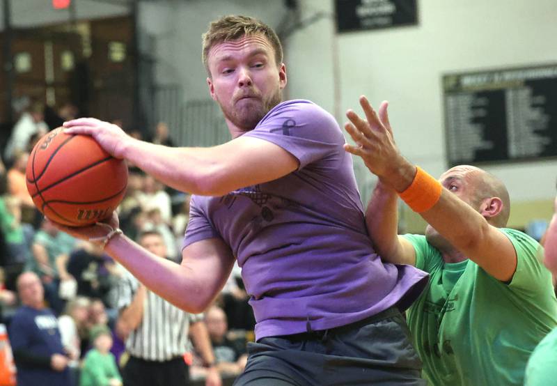 Sycamore School Staff team member Jake Winters grabs a rebound in front of a Fire/Police team member Thursday, Dec. 19, 2024, during the Heroes on Hardwood basketball game at Sycamore High School. The basketball game, which is a fundraiser for the Spartan Food Pantry, pits a team of Sycamore first responders against a squad of Sycamore School District 427 staff.
