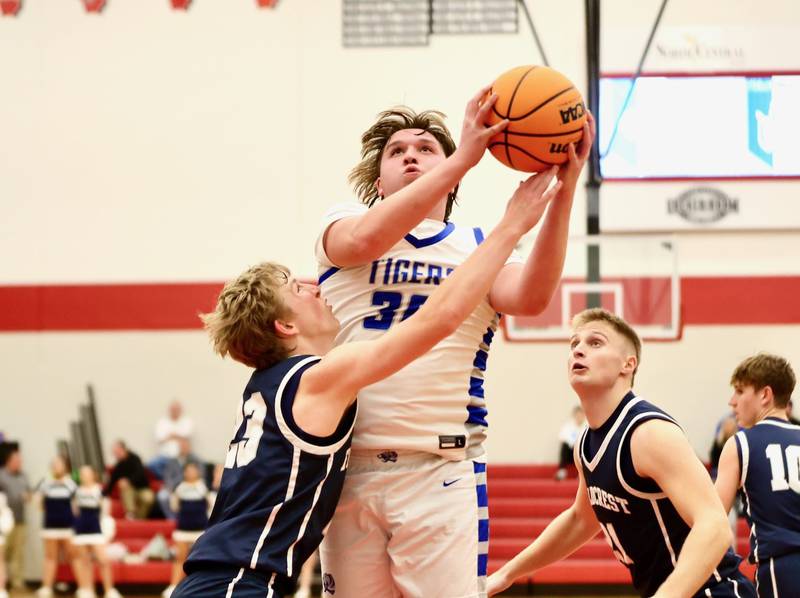 Princeton's Jordan Reinhardt shoots against Fieldcrest's Jordan Heider Tuesday night at Hall High School.