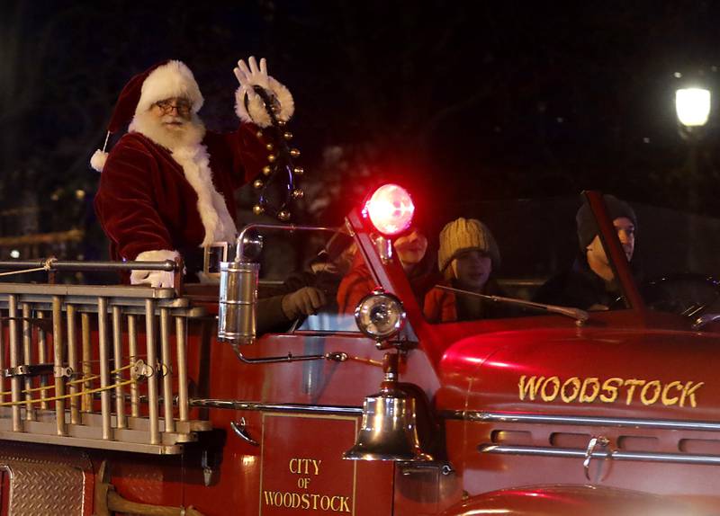 Santa and Mrs. Claus wave to the crowd from a fire truck during the Lighting of the Square Friday, Nov. 24, 2023, in Woodstock. The annual holiday season event featured brass music, caroling, free doughnuts and cider, food trucks, festive selfie stations and shopping.