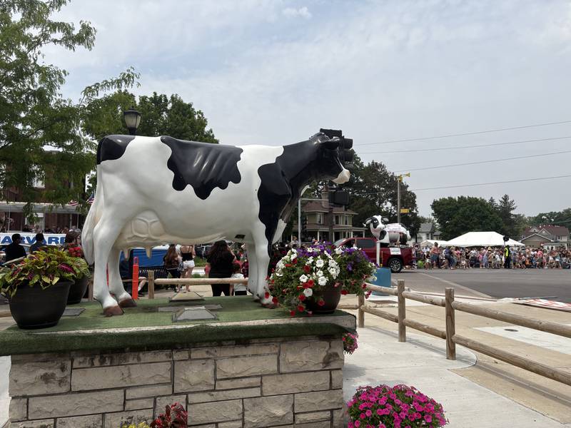 A float with Harvard Mayor Michael Kelly and an inflatable cow drives by the Harmilda statue during the Harvard Milk Days parade June 7, 2025.