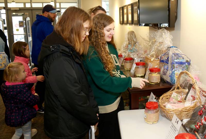 Maylin Isel and Grace Joyce check out the raffle items at the Yorkville Public Library Mini Golf FUN Raiser on Sunday, Feb. 2, 2025 in Yorkville.