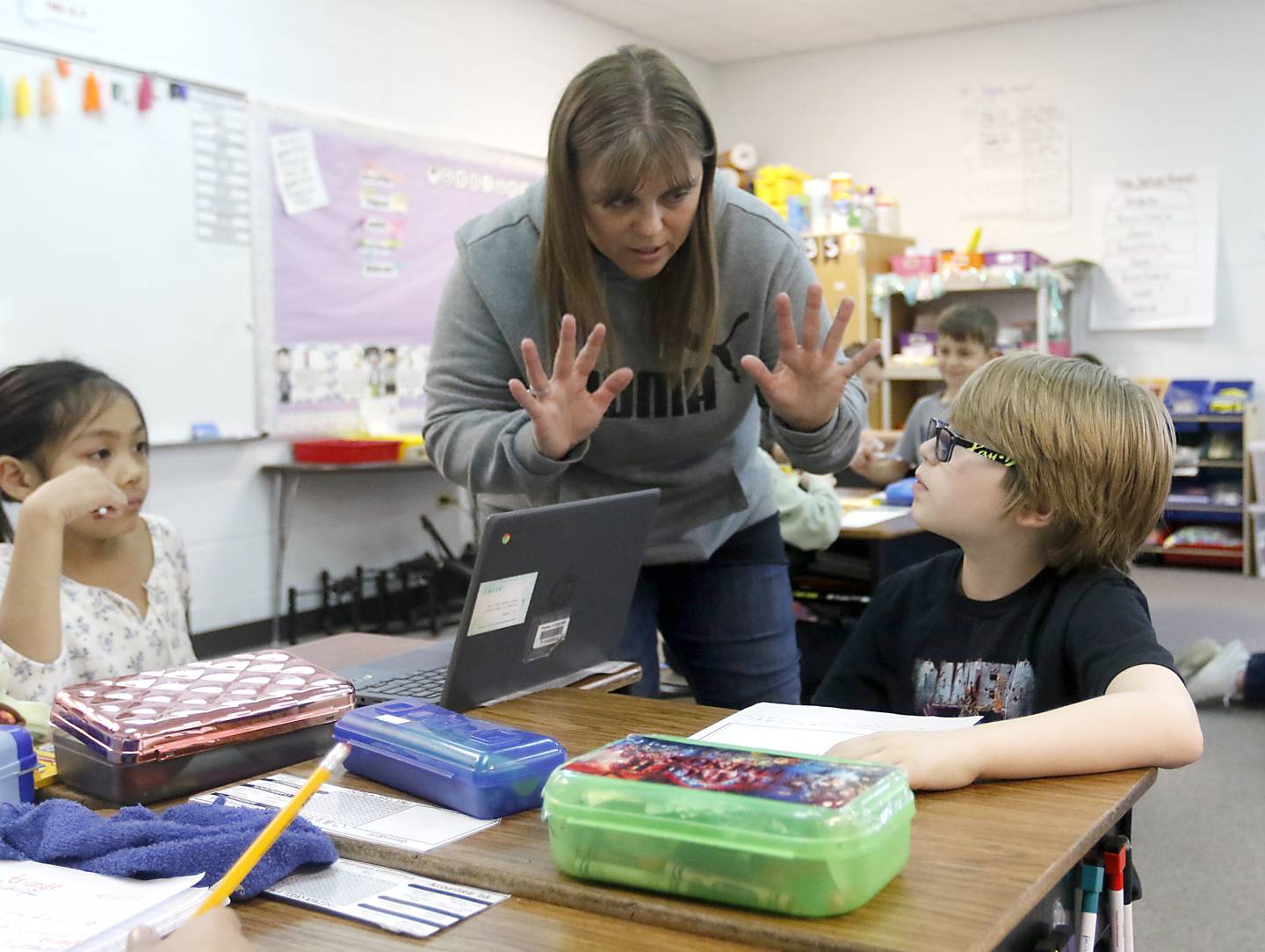 Zoki Russo, a third grade teacher at Sleepy Hollow Elementary School, works with Gunner Bell as she teaches her class.