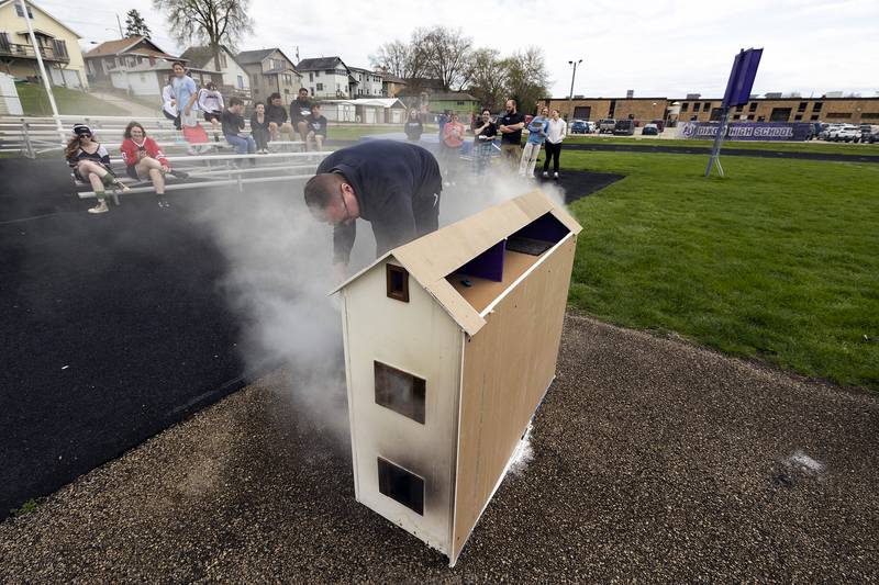 Dixon City Fire chief Ryan Buskohl douses one of the model homes Tuesday, April 22, 2025, at Dixon High School. The forensic class will dismantle the models and learn about fire and smoke patterns to learn about traits of arson.