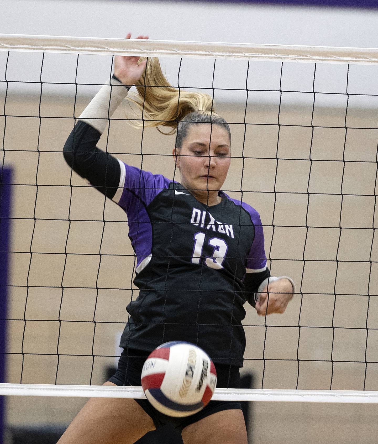 Dixon’s Solis Thompson driops the ball over the net against North Boone Tuesday, Sept. 24, 2024, in Dixon.