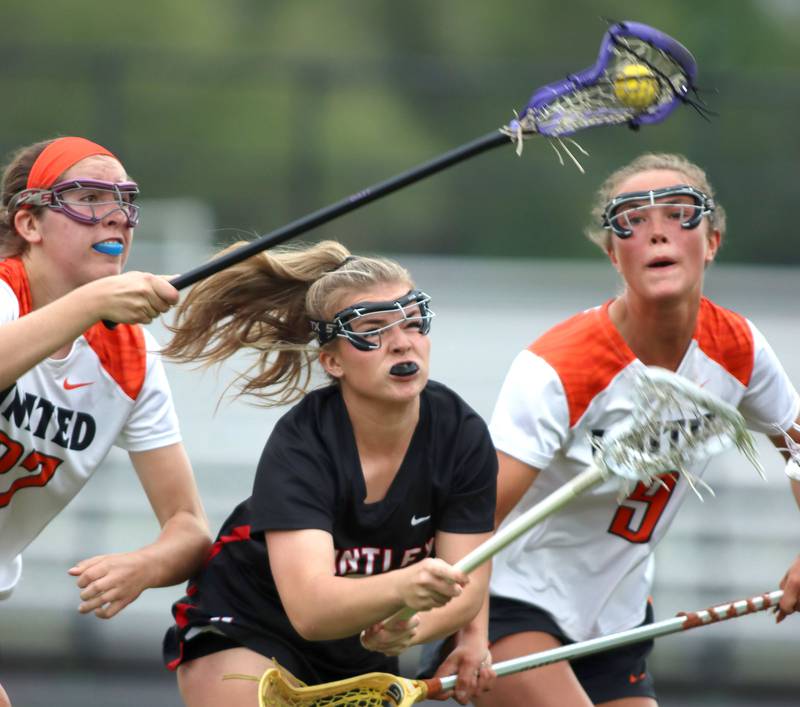Crystal Lake Central United’s Anna Starr, left, and Fiona Lemke, right, battle Huntley’s Leah Holmberg, center,  in IHSA Sectional Title Game action at Crystal Lake Central High School in Crystal Lake on Friday, May 30, 2025.