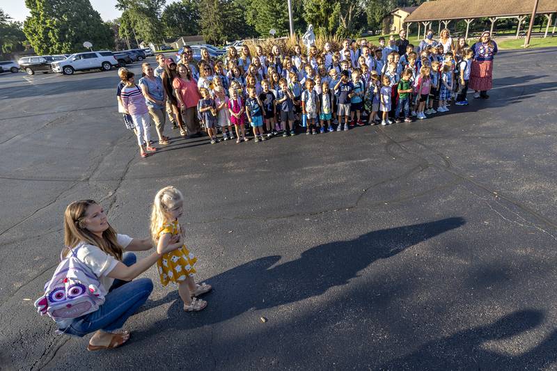 Jaselyn Nagy wrangles daughter Stella, 3, Wednesday, Aug. 13, 2025, outside of St. Anne’s School in Dixon. The pre-K youngster had had enough of pictures so resisted joining the rest of the school in a group photo to start the new year.