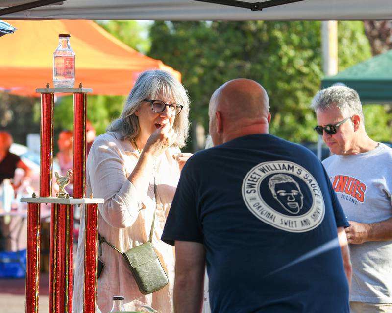 Linda Korbus of Westchester talks with Bill Steber on Sunday Sep. 1, 2024, while tasting sLinda Korbus of Westchester talks with Bill Steber on Sunday Sep. 1, 2024, while tasting some of the Sause from Sweet Silliam’s Sauce from Villa Park during the Cue for a Cause event in downtown Elmhurst.ome of the Sause from Sweet Silliam’s Sauce from Villa Park during the Cue for a Cause event in downtown Elmhurst.