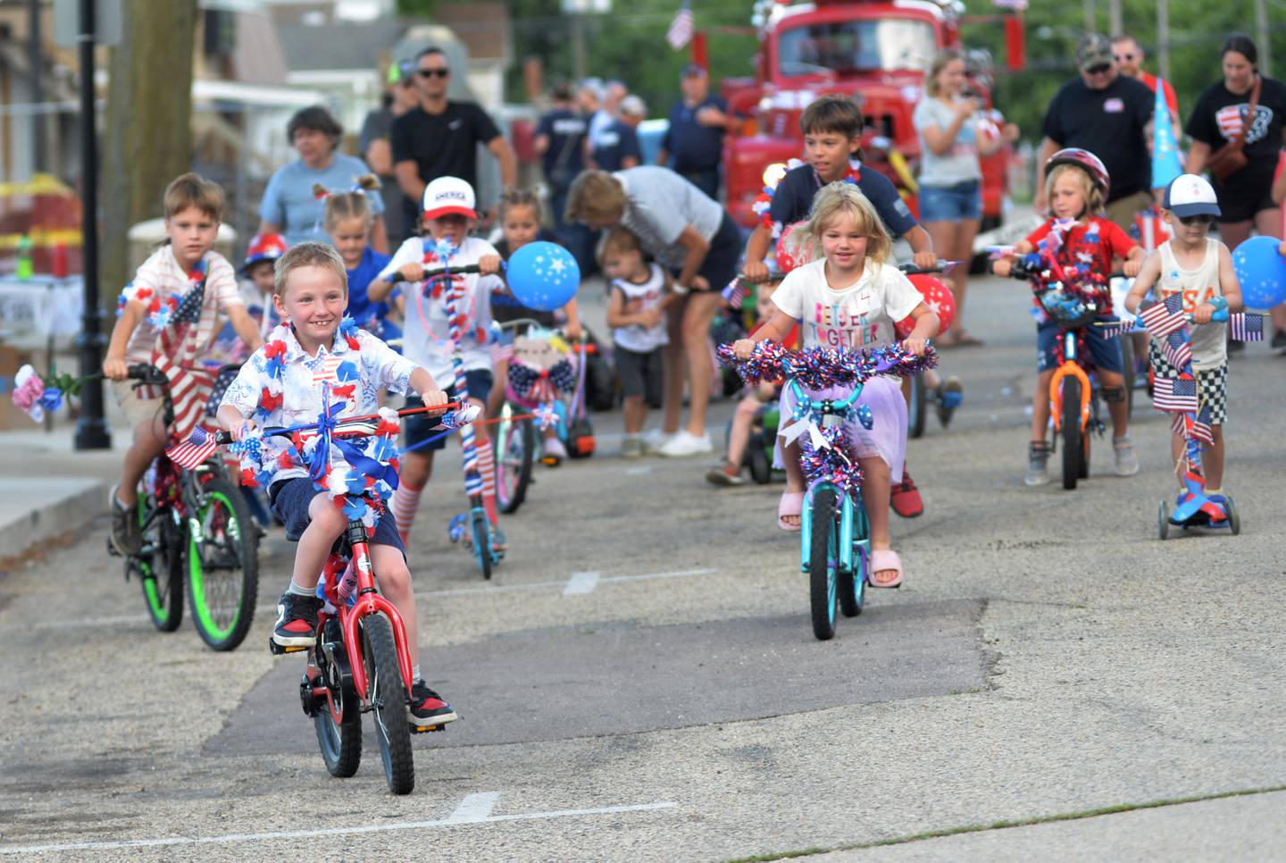 Austin Anderson, 7, of Madison, Wisconsin, leads the pack on his red bicycle at the start of the Kiddie Parade at the Let Freedom Ring festival in Mt. Morris on Friday, July 5, 2024.