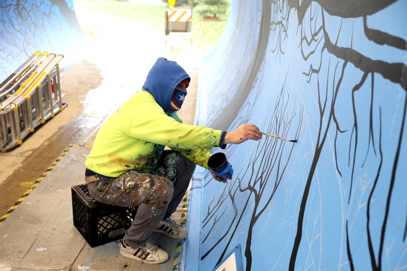 Artist Juan De La Mora works on his mural in the Taylor Avenue pedestrian underpass in Glen Ellyn on Wednesday, Nov. 16, 2022. De La Mora’s piece will feature the four seasons as you progress through the tunnel.