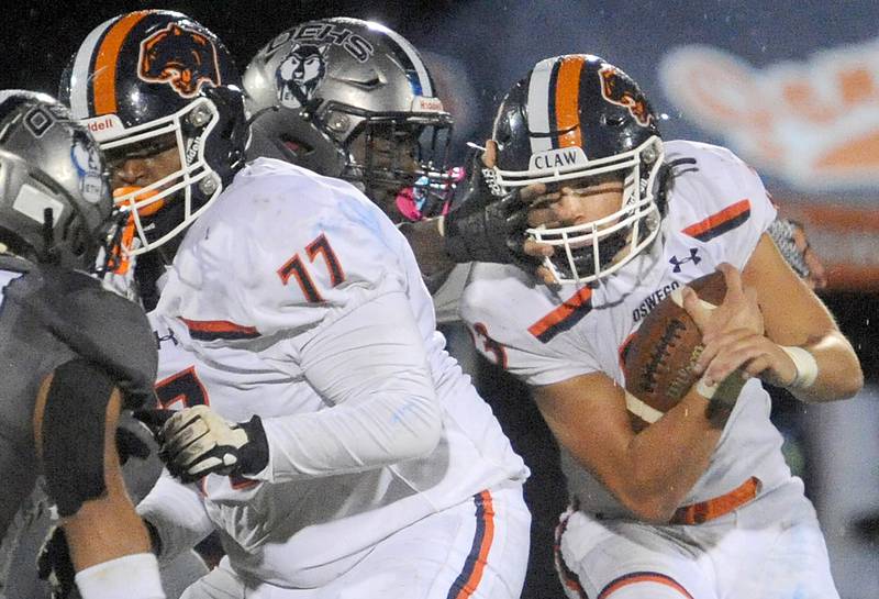 Oswego East running back Braedon Hellinger (23) gets facemasked by an Oswego East defender during a varsity football game at Oswego East High School on Friday, Oct. 14, 2022.