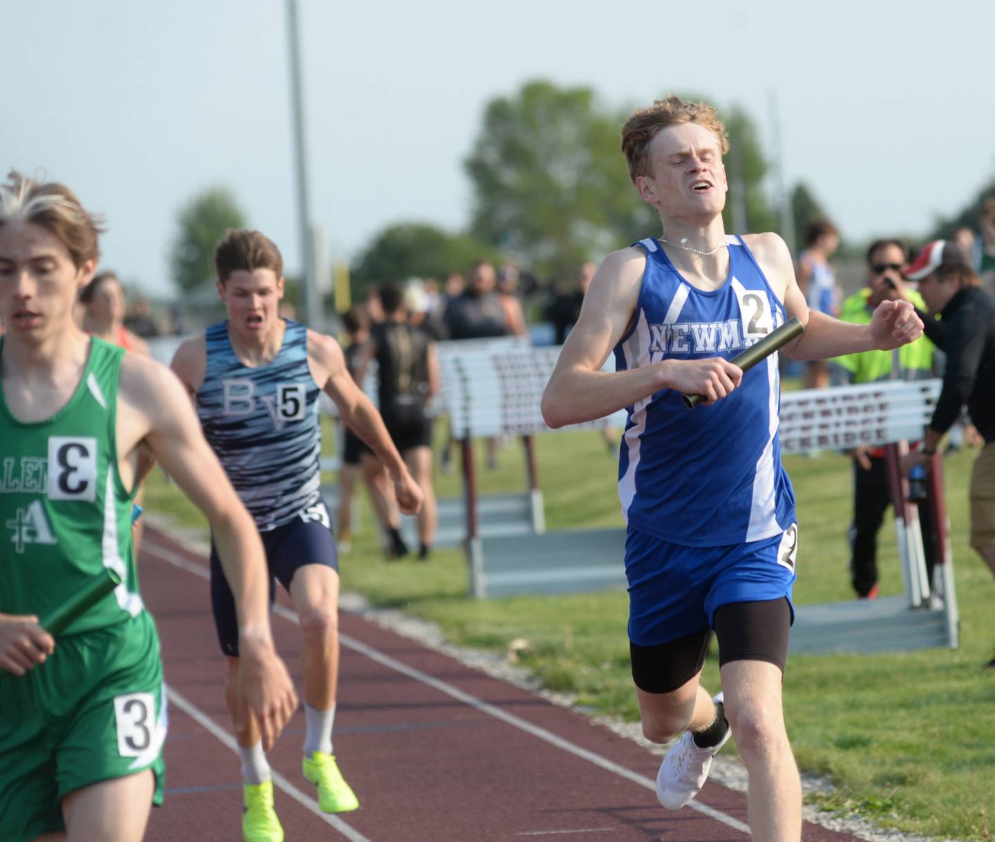 Newman's Lucas Simpson crosses the finish line behind a Rock Island Alleman runner during the 4x800 relay at the 1A Rockridge Sectional on Friday, May 19.