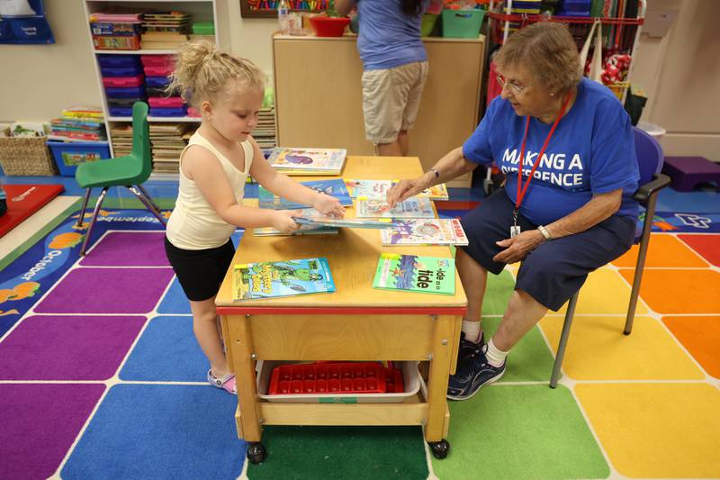 Scarlett Halm, 3, picks out a book from volunteer Shirley Anderson’s library at the C.W. Avery YMCA summer camp in Plainfield. Wednesday, July 20, 2022 in Plainfield.