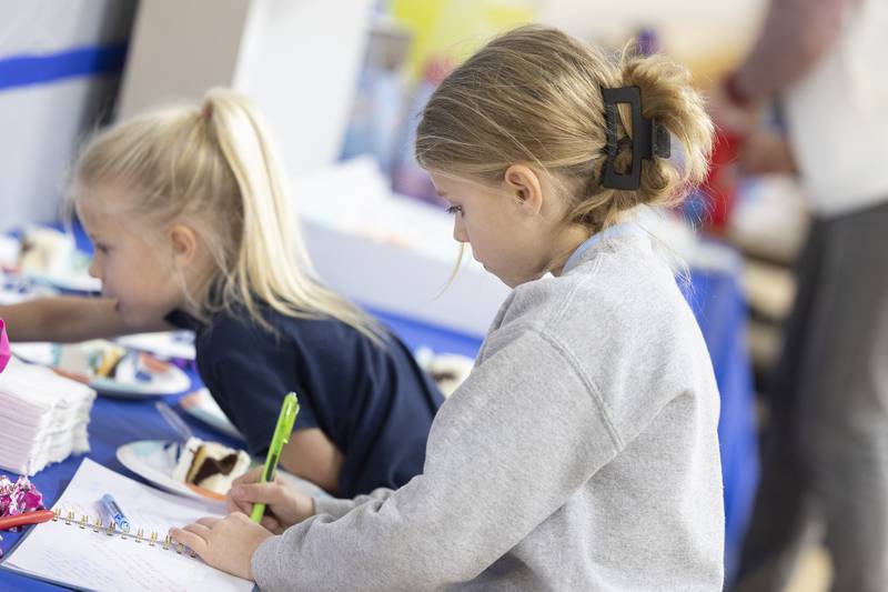 Eleanor LeMay, 7, signs Mortonson’s congratulation book Wednesday, Dec. 17, 2025, during the retirement party. All three LeMay children took swim lessons from Deb.