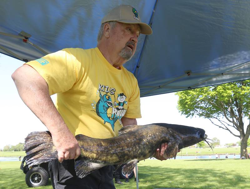 Ken Clodfelter retired biologist form the Department of Natural Resources, shows kids a large 22-pound flathead catfish during the 25th annual Kids Fishing Expo on Saturday, May 10, 2025 at Baker Lake in Peru.