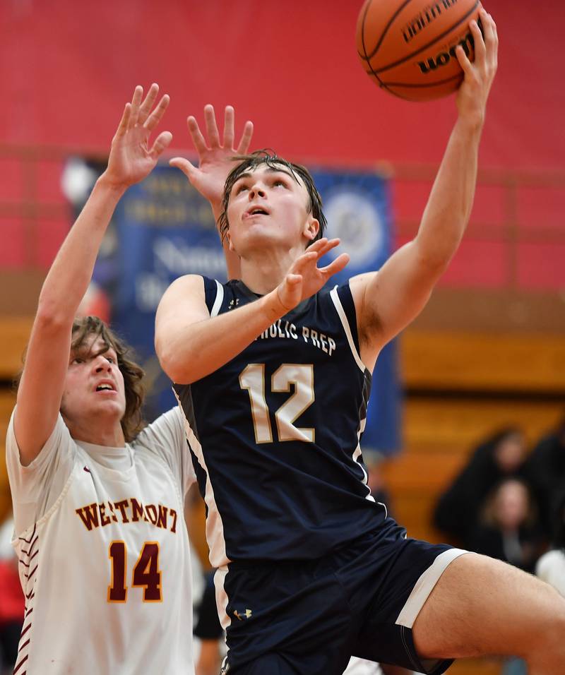 IC Catholic's Jake Gallagher lays the ball up in front of Westmont's Billy McGhie (14) during a game on Jan. 5, 2024 at Westmont High School in Westmont.
