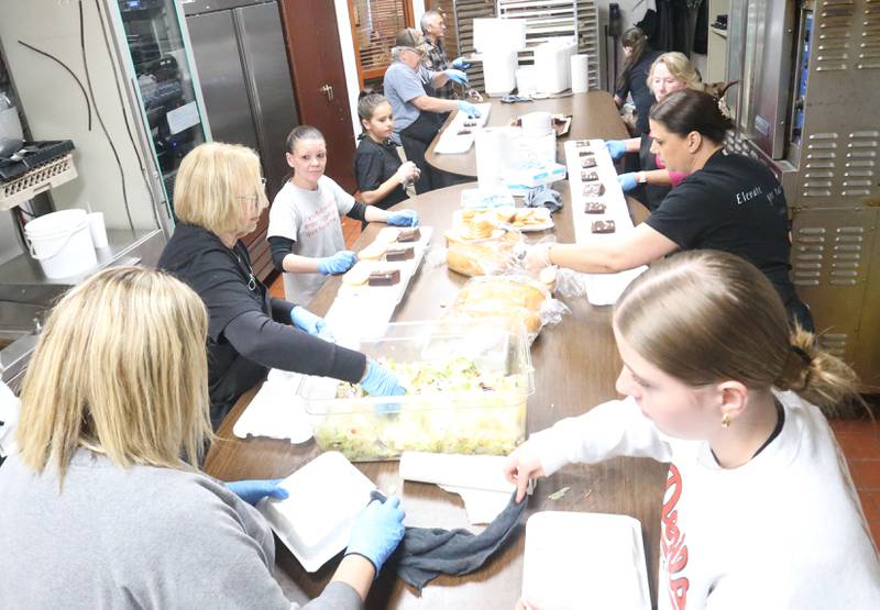 Volunteers help package salad and dessert or the 27th annual Lighted Way Spaghetti Dinner on Monday, April 20. 2025 at Uptown downtown La Salle.