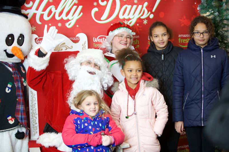 Madeline (5), Robin(7), Kendall and Lanna Milashoski (11) visit with Frosty, Santa and Mrs. Claus at the Holly Days Winter Festival on Saturday, Dec. 3,2022 in Westmont.