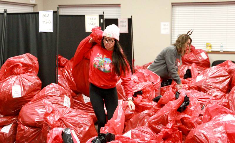 Daniela Saracco carries a bag full of gifts for one of 550 St. Charles School District 303 children on Tuesday, Dec. 3, 2024 for the annual Big Hearts of Fox Valley Christmas Gift Sponsorship Program.