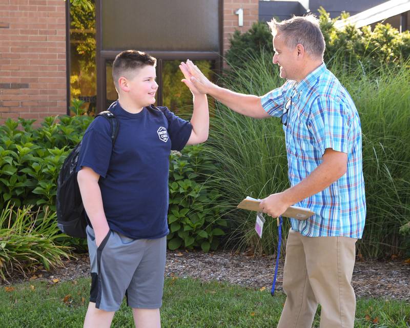 Western Avenue Elementary School Principal Casey O’Connell greets a student on the first day of school on Thursday Aug. 21, 2025, in Geneva.