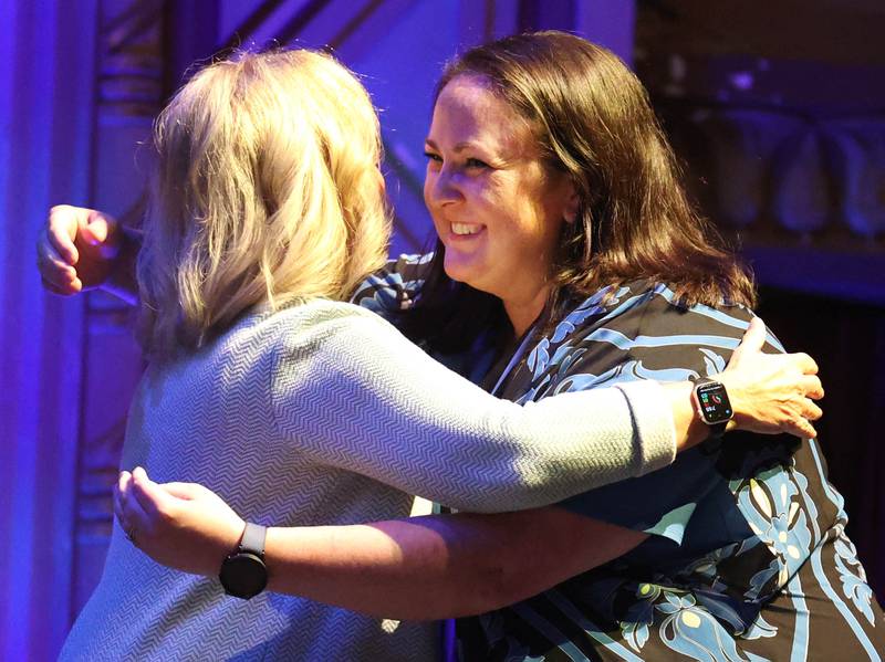 Sabrina Nicholson (right) gets a hug as she is introduced as an Athena Award finalist Thursday, Oct. 10, 2024, during the Athena and Women of Accomplishment Awards reception hosted by the DeKalb Chamber of Commerce at the Egyptian Theatre.