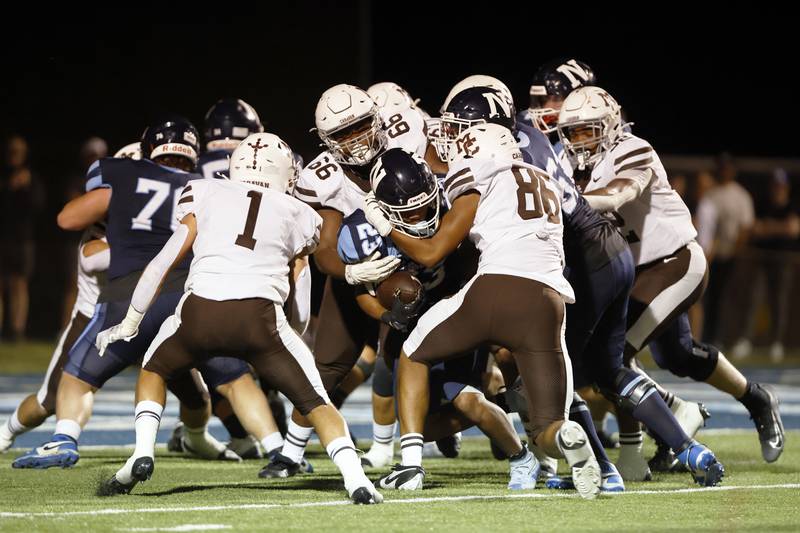 Nazareth's Justin Watson (23) is wrapped up by the Mt. Carmel defense during the varsity football game between Mt. Carmel high school and Nazareth Academy on Friday, Sept. 12, 2025 in La Grange Park, IL.