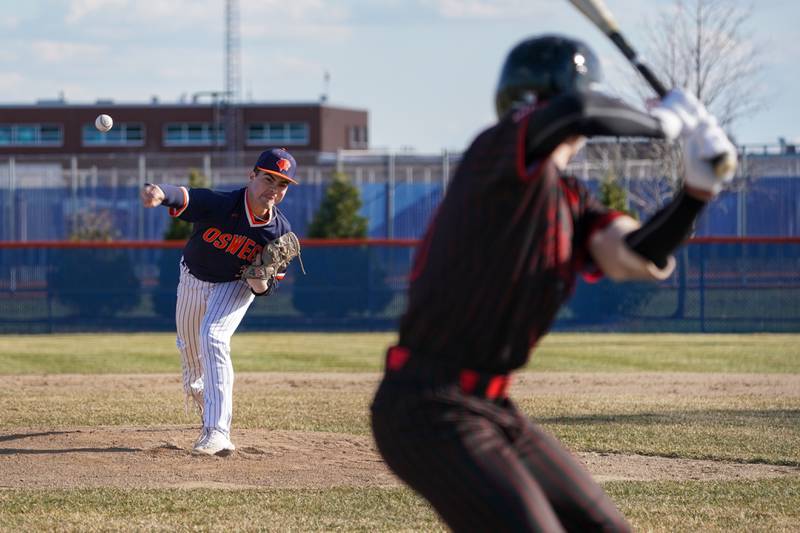Oswego’s Brogan Mello (3) delivers a pitch against Benet during a baseball game at Oswego High School on Tuesday, March 25, 2025.
