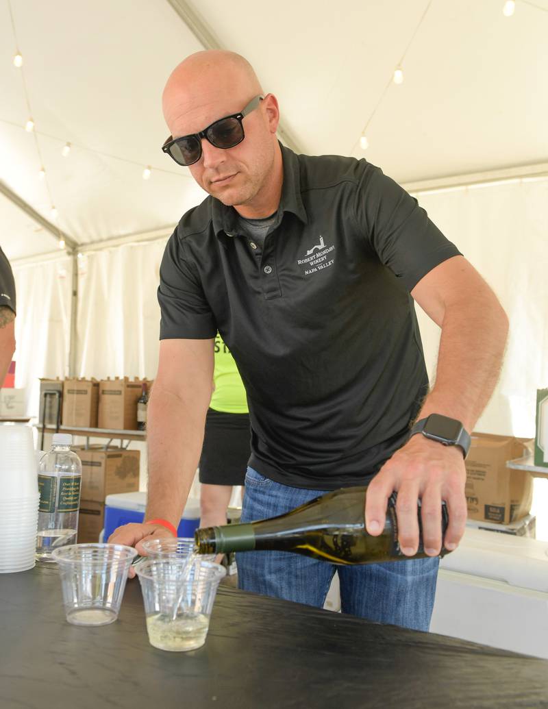 Steve Frey of Constellation Brands pours three glasses of Kim Crawford Sauvignon Blanc during the Festival of the Vine in Geneva on Friday, September 9, 2022.