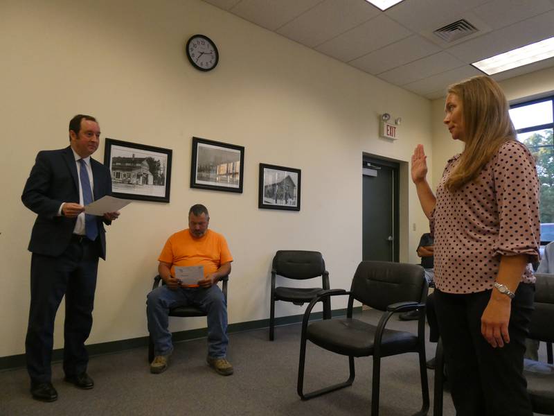 McHenry accountant Katherine Andrus, right, is sworn in by village attorney Mike Smoron, left, as new treasurer for the village of Hebron on Monday, Aug. 22, 2022, after village President Robert Shelton indicated past disagreements with Andrus' predecessor, Susan Fotland.